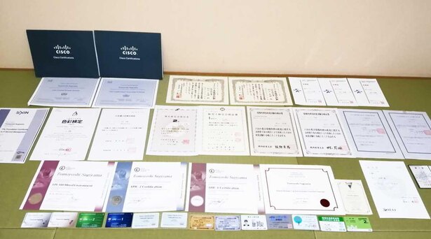 杉山さんが今まで取得した資格の合格証の数々。IT関連資格を中心に、士業、アロマテラピー検定やeco検定まで、取得資格の種類は多岐にわたっている
